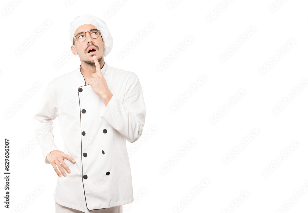 Surprised young chef making a gesture of doubt Surprised young chef making a gesture of doubt