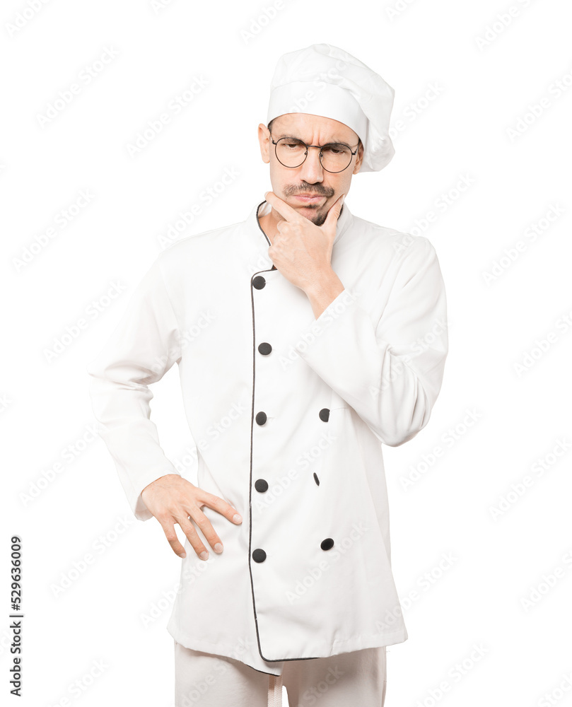 Concerned young chef making a gesture of doubt Concerned young chef making a gesture of doubt