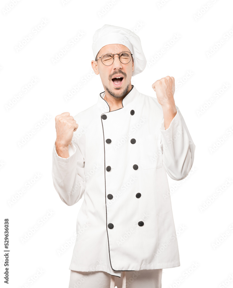 Competitive young chef making a gesture of celebration Competitive young chef making a gesture of celebration
