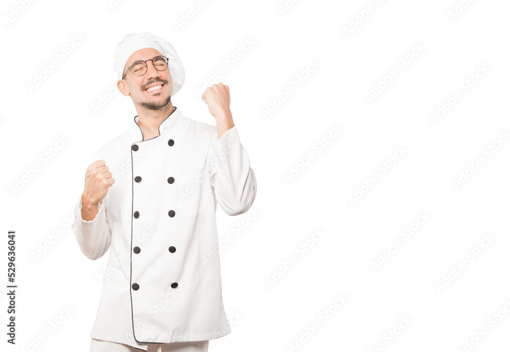 Competitive young chef making a gesture of celebration Competitive young chef making a gesture of celebration