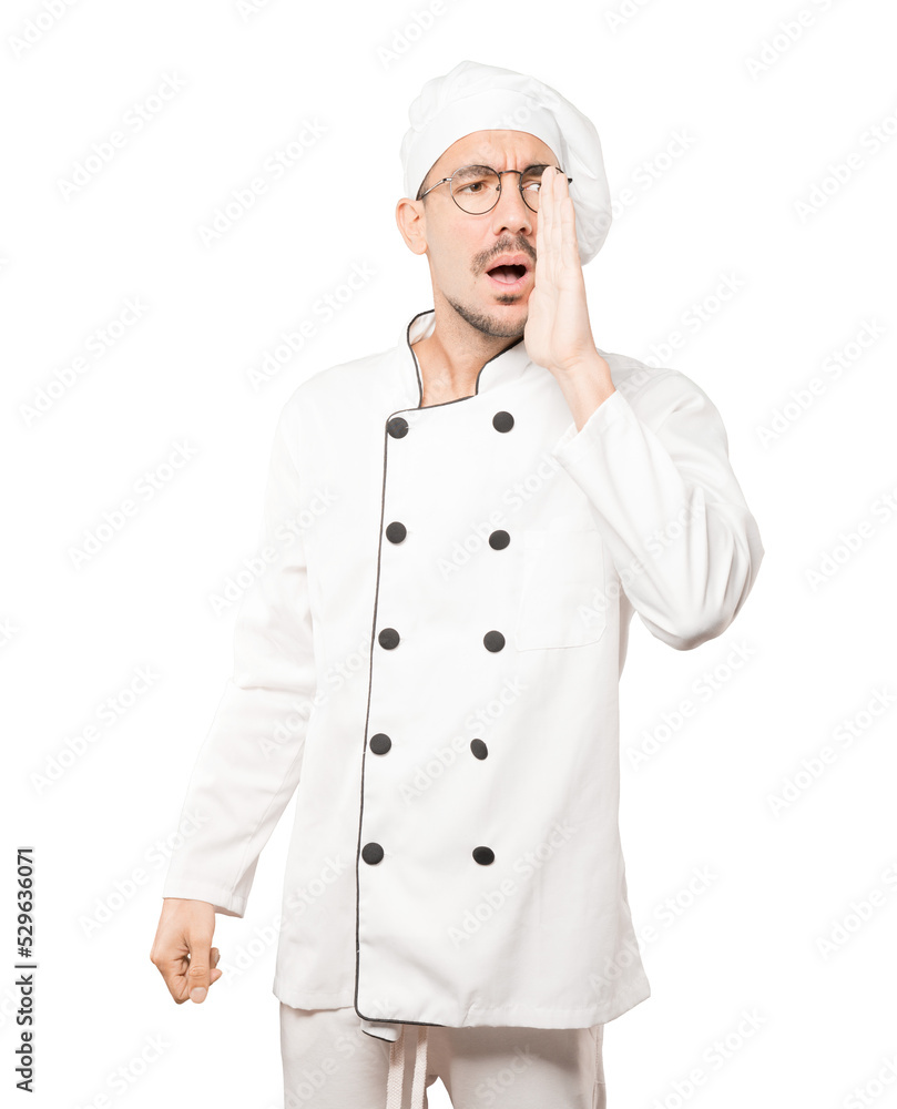 Happy young chef trying to say something strongly Happy young chef trying to say something strongly