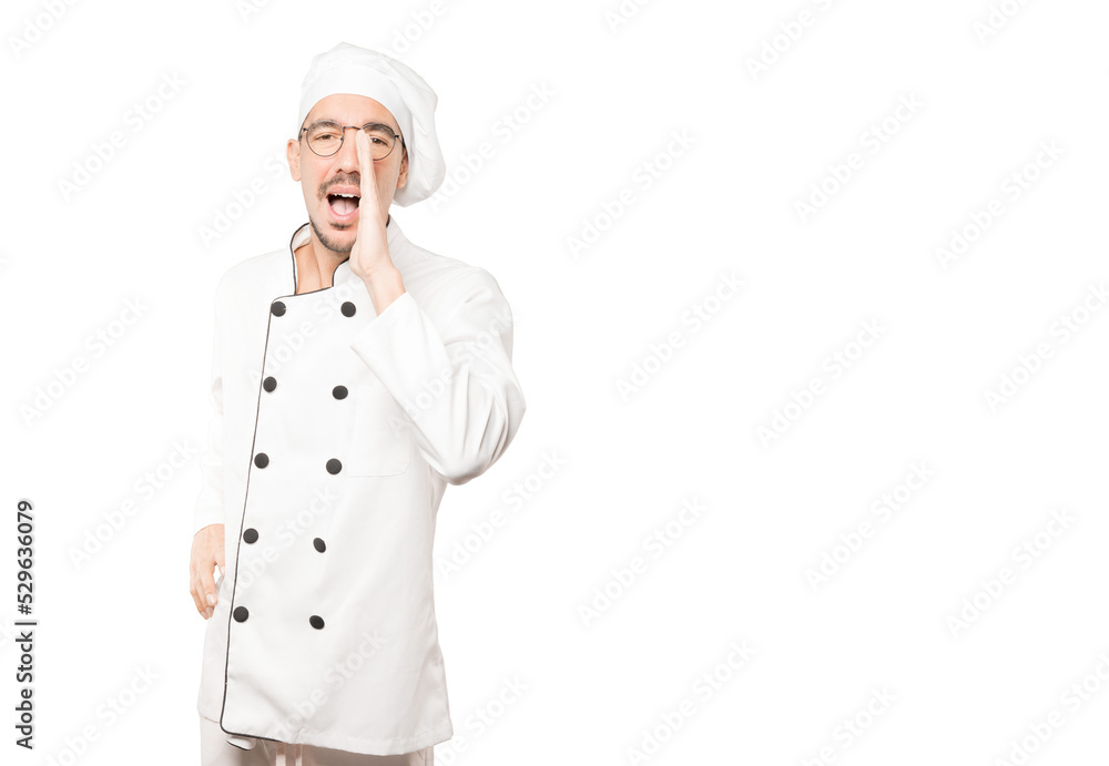 Happy young chef trying to say something strongly Happy young chef trying to say something strongly