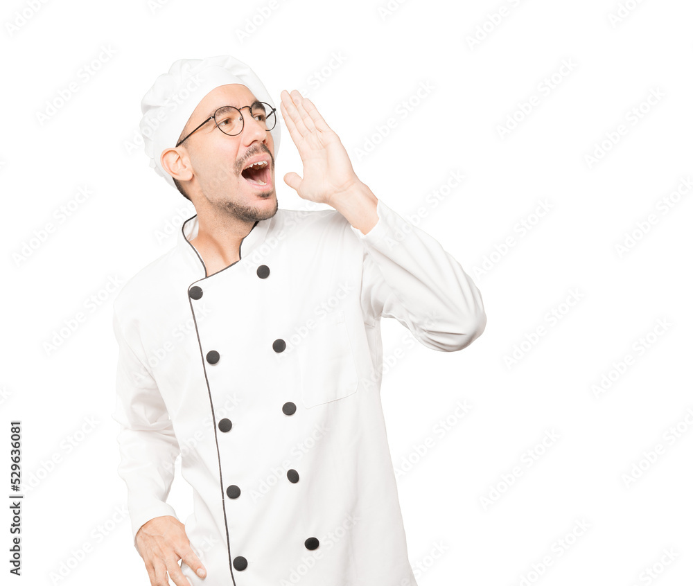 Happy young chef trying to say something strongly Happy young chef trying to say something strongly