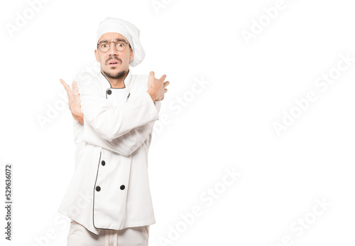 Concerned young chef making a gesture of being cold