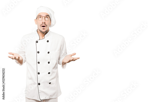 Happy young chef looking up gesture