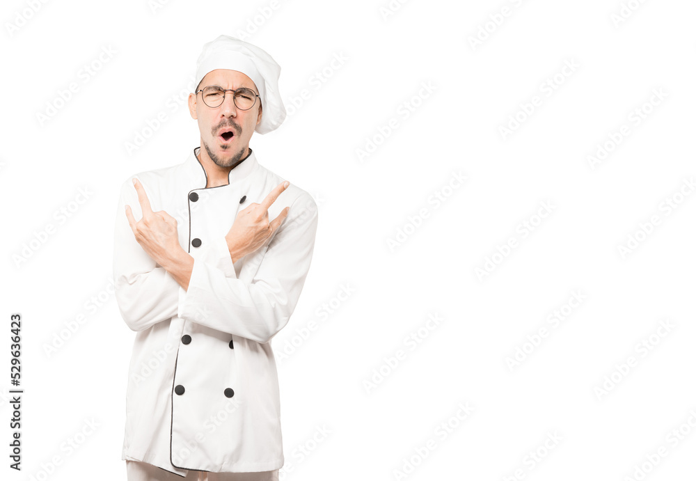 Naughty young chef making a rock gesture Naughty young chef making a rock gesture
