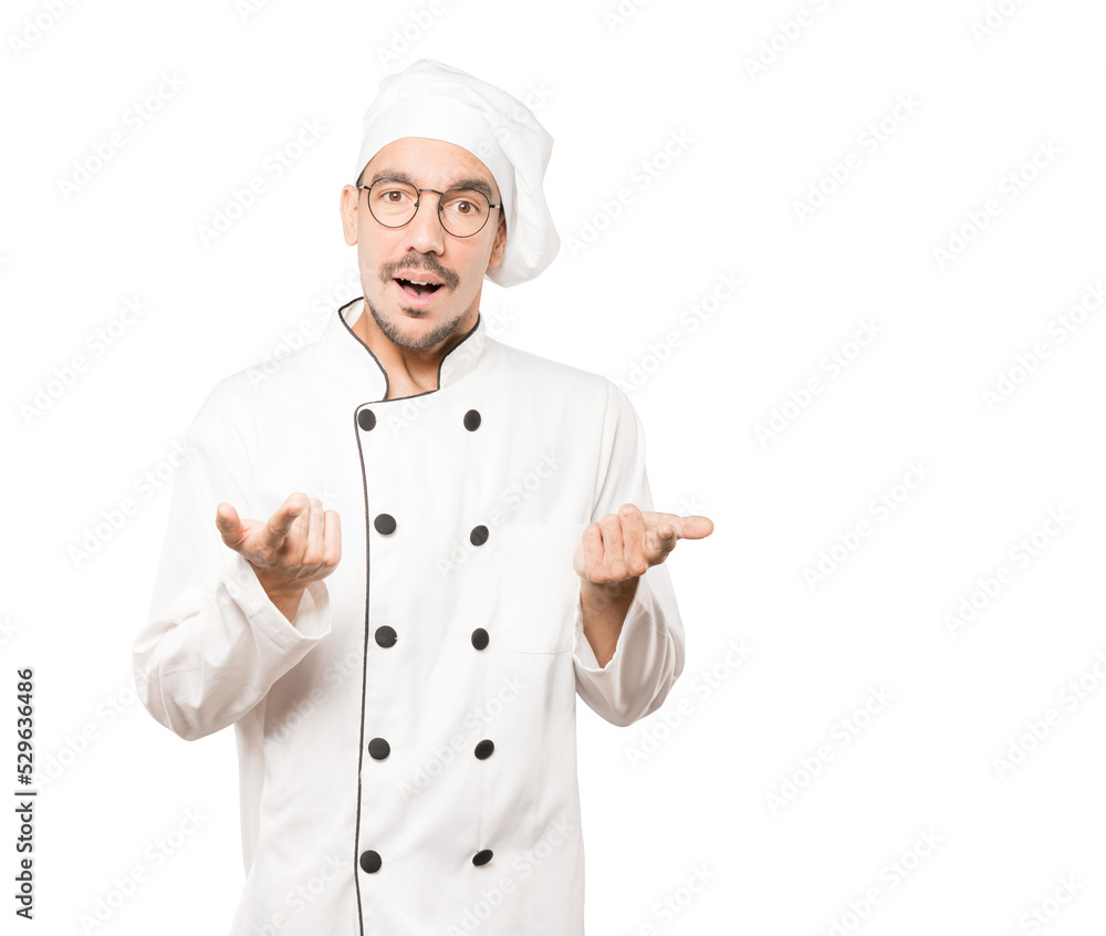 Amazed young chef pointing at you with his finger Amazed young chef pointing at you with his finger