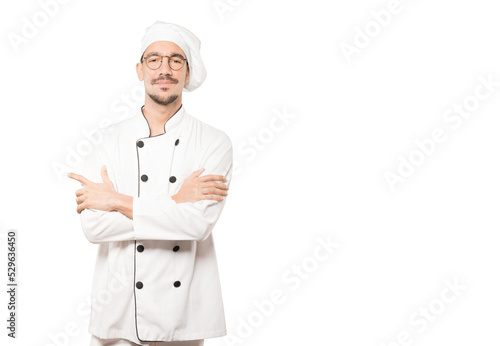 Satisfied young chef with crossed arms gesture photo