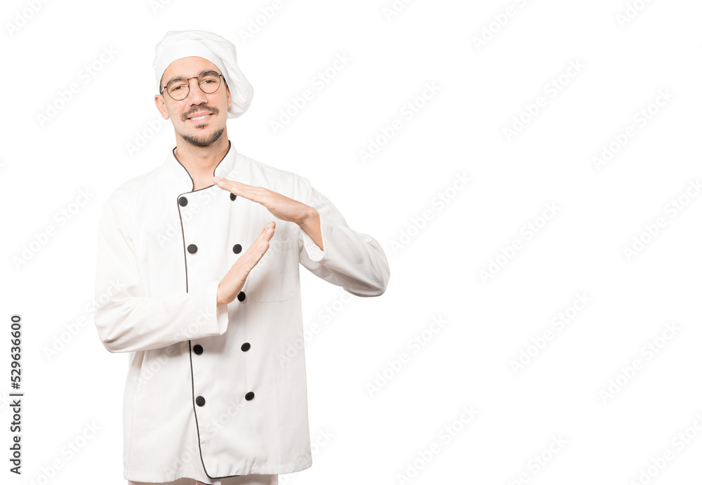 Stressed young chef making a time out gesture with his hands Stressed young chef making a time out gesture with his hands