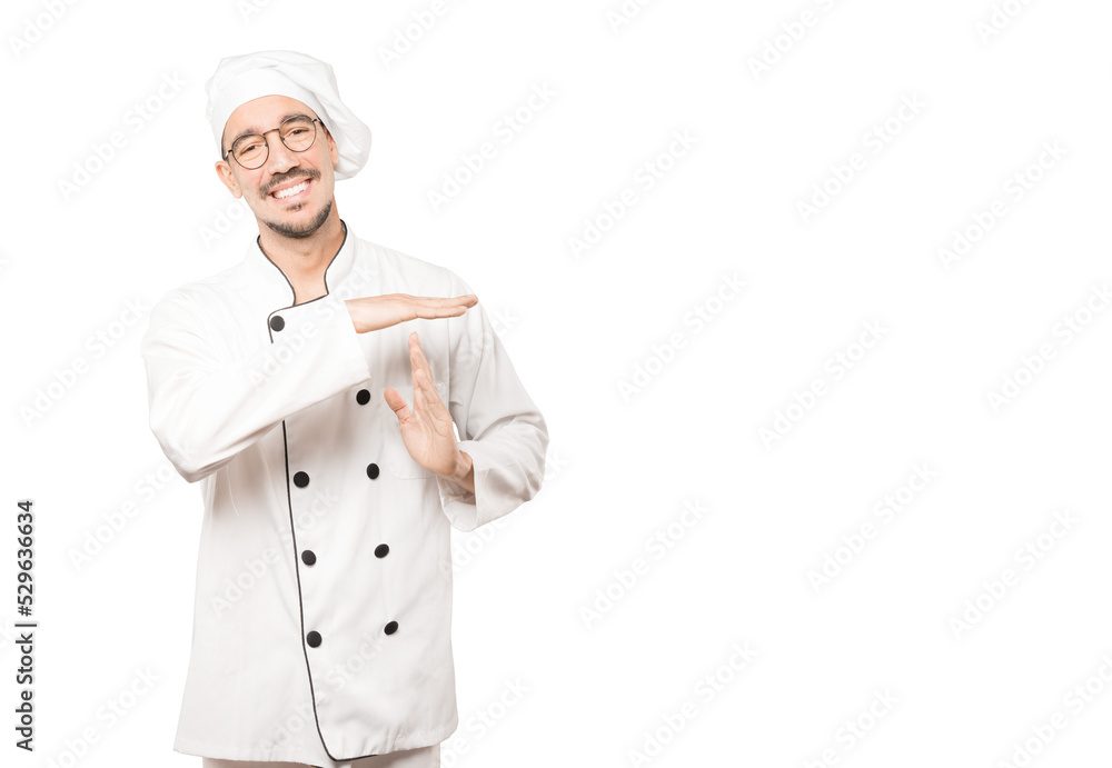 Friendly young chef making a time out gesture with his hands Friendly young chef making a time out gesture with his hands