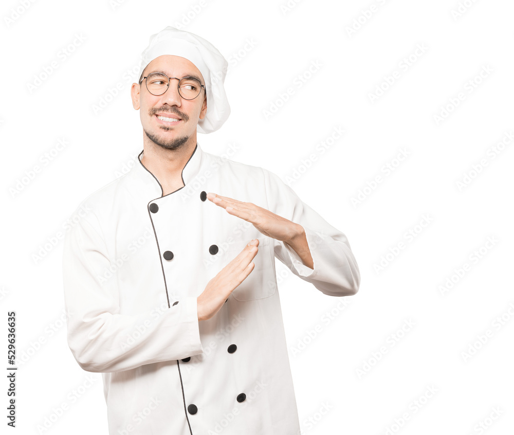 Friendly young chef making a time out gesture with his hands Friendly young chef making a time out gesture with his hands