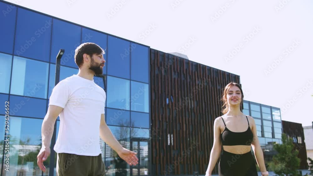 Active caucasian couple in sport clothes enjoying morning exercises together on fresh air. Positive young man and woman training regularly at urban area for fit and healthy body. Active caucasian couple in sport clothes enjoying morning exercises together on fresh air. Positive young man and woman training regularly at urban area for fit and healthy body.