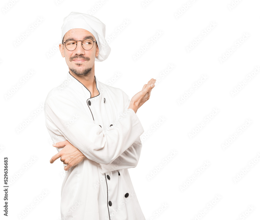 Puzzled young chef doing a gesture of not understand Puzzled young chef doing a gesture of not understand