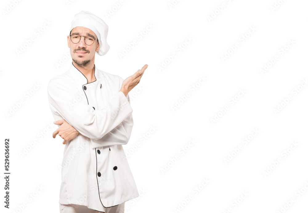 Puzzled young chef doing a gesture of not understand Puzzled young chef doing a gesture of not understand