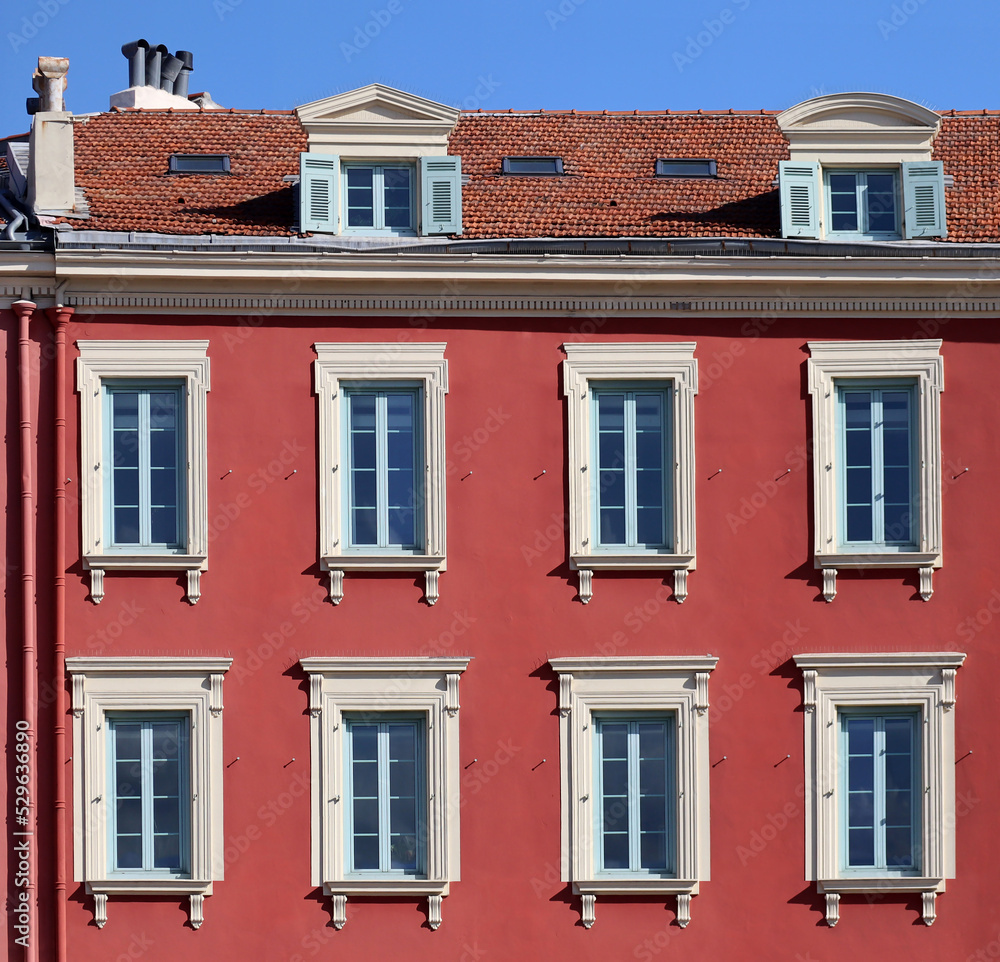 Typical facade in the south of France, on the French Riviera, windows with colored shutters