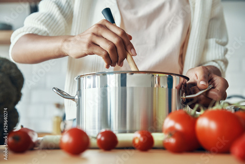 Close-up of unrecognizable woman mixing something in pan while preparing food at the kitchen