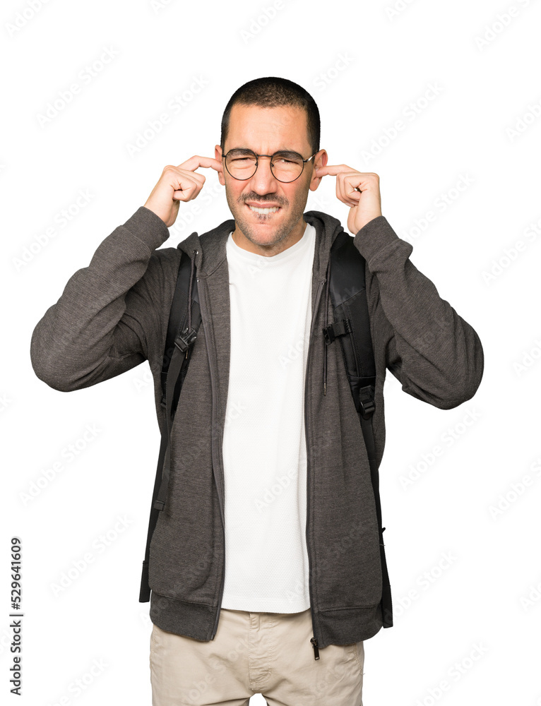 Concerned student worried about loud noises and covering his ears Concerned student worried about loud noises and covering his ears