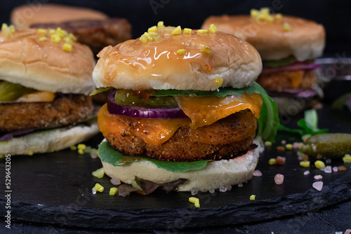 Vegan meatless seitan cheeseburger and vegan on slate plate