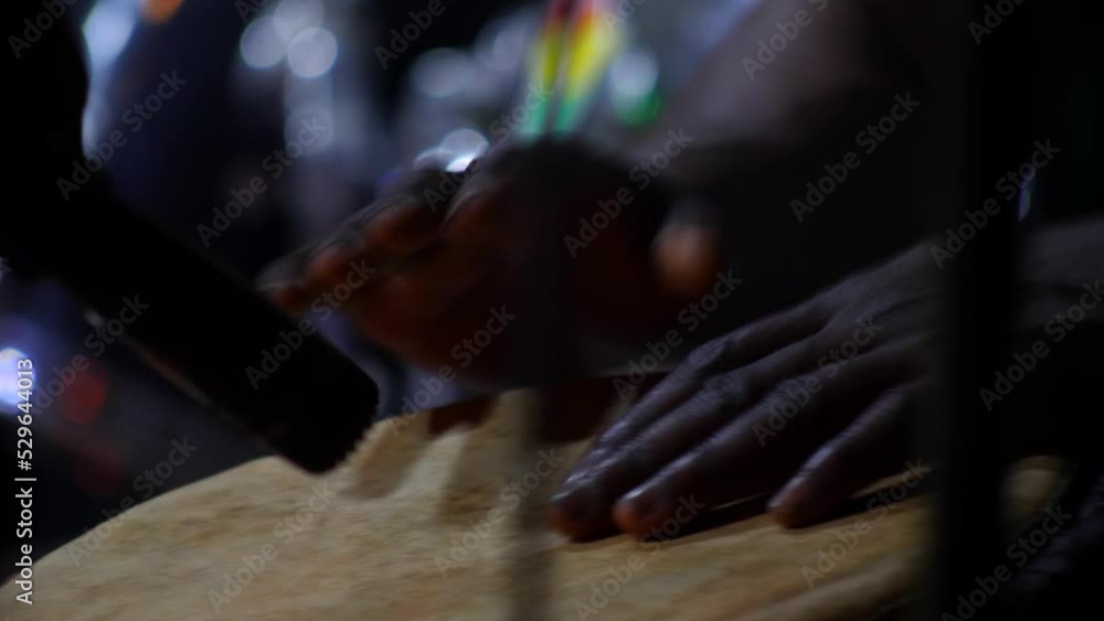 Black hands playing djembe hold between his knees in front of microphone, Abene, Casamance, Senegal, staying still. Black hands playing djembe hold between his knees in front of microphone, Abene, Casamance, Senegal, staying still.