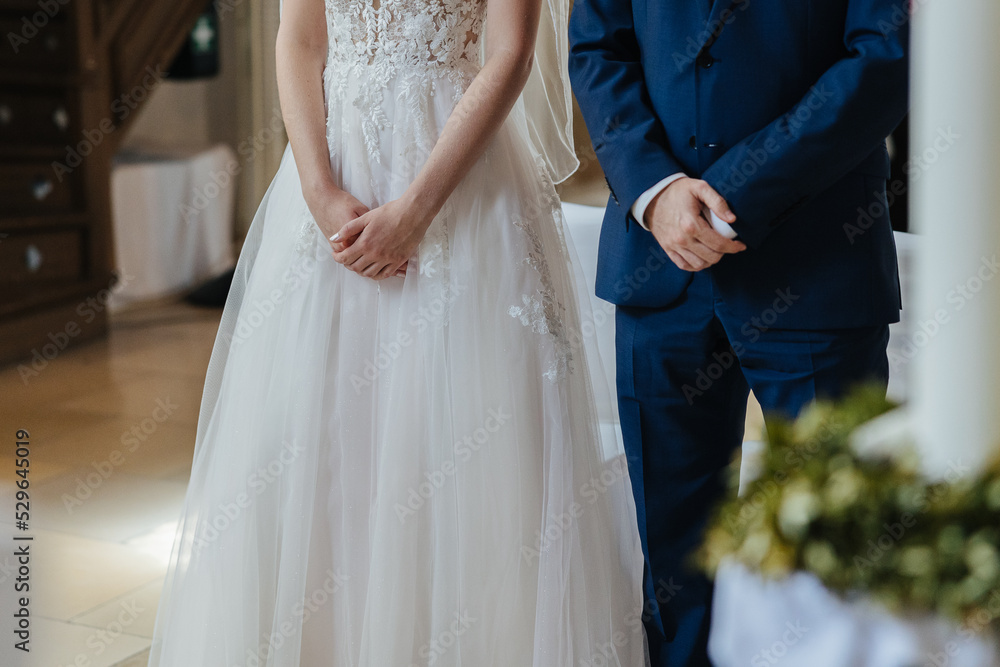 Fototapeta premium Bride and groom standing next to each other, hands close-up
