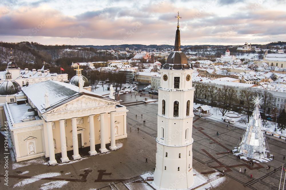 Aerial Vilnius city panorama in winter with snow covered houses, churches and streets. Cathedral square and Christmas tree. Winter city scenery in Lithuania.