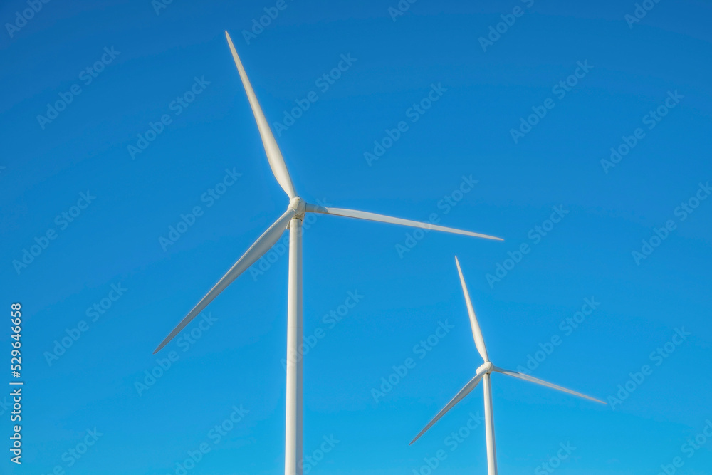 Windmills alternative energy source against clear blue sky background Windmills alternative energy source against clear blue sky background