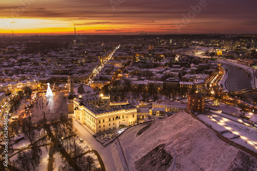 Beautiful Vilnius city panorama in winter with snow covered houses  churches and streets. Aerial evening view. Winter city scenery in Lithuania.