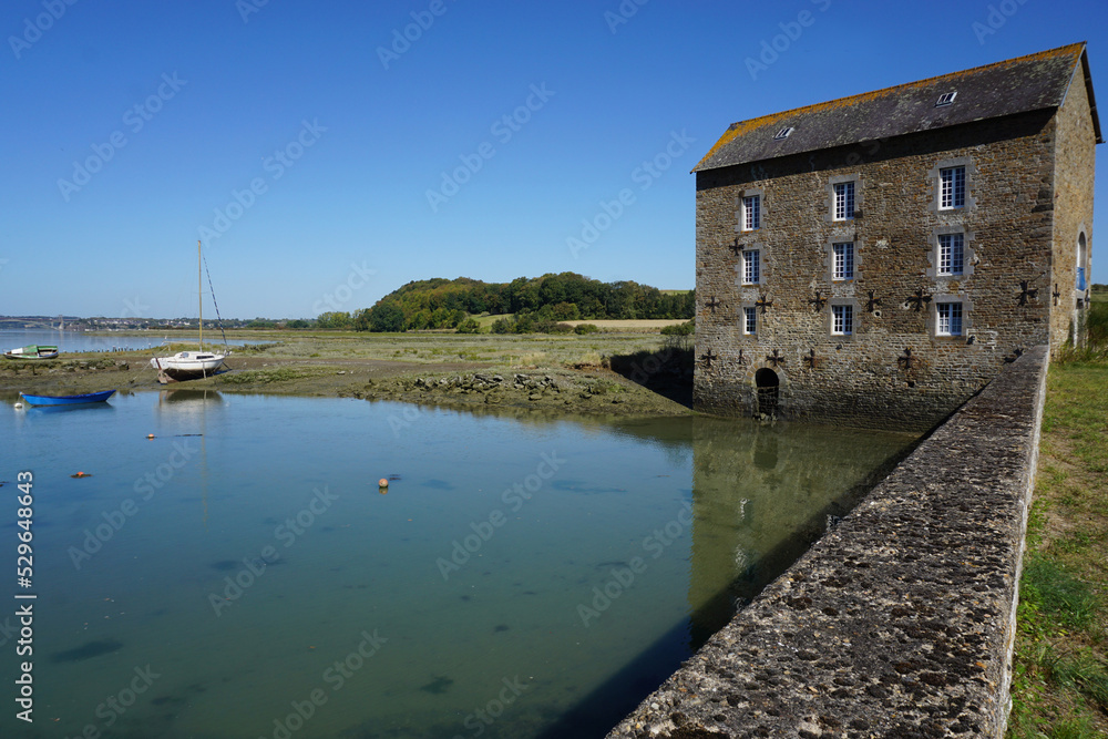 old stone mill by the ocean in brittany france at low tide