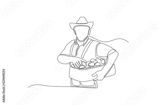 Single one line drawing man with freshly harvested box. Thanks giving concept. Continuous line draw design graphic vector illustration.