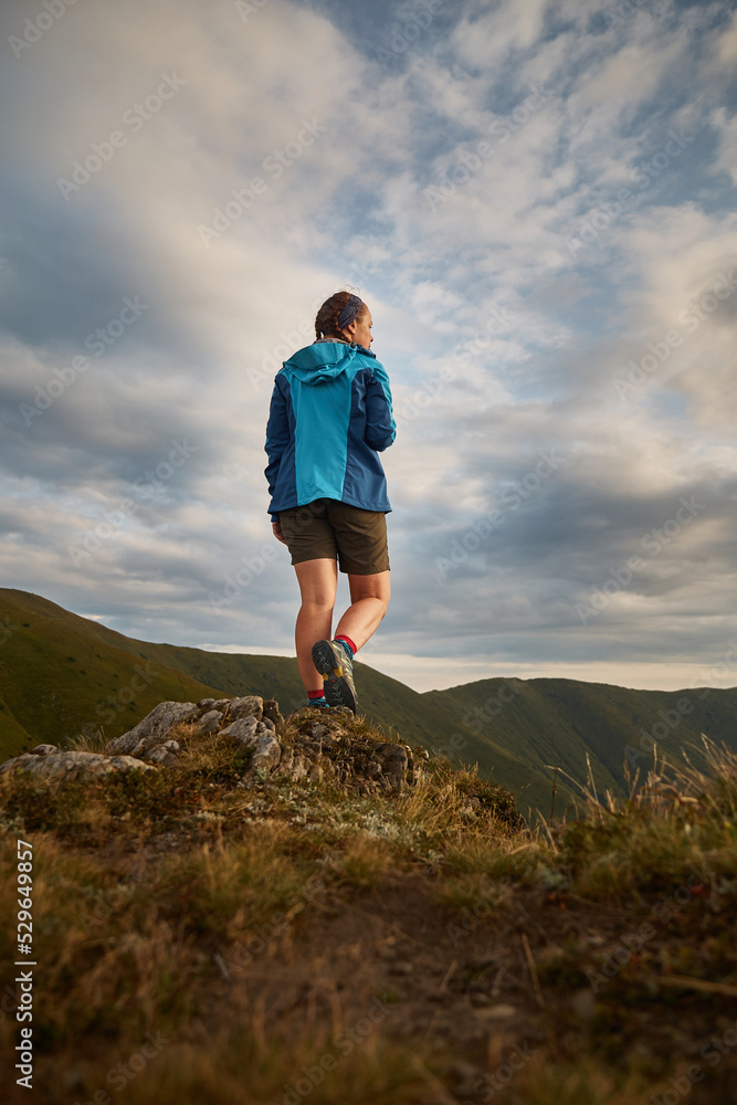 Naklejka premium Female tourist enjoy view of Mountain range. Carpathian Mountain, Ukraine. Walking and hiking trails in Borzhava ridge. Rural area of carpathian mountains in autumn