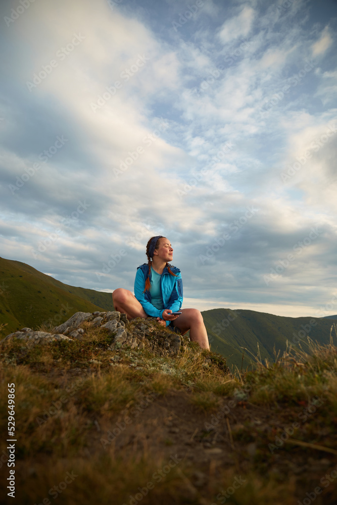 Female tourist sitting and enjoy view of Mountain range. Carpathian Mountain, Ukraine. Walking and hiking trails in Borzhava ridge. Rural area of carpathian mountains in autumn