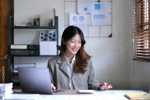 Portrait of smiling beautiful business asian woman working in office use computer with copy space.