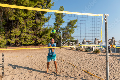 Beach volleyball player with the ball in motion and action.Sport, healthy lifestyle, activity, movement concept. Copyspace.