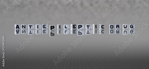 antiepileptic drug word or concept represented by black and white letter cubes on a grey horizon background stretching to infinity photo