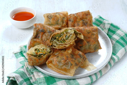 Martabak Telur or omelette murtabak, savory pan-fried pastry stuffed with egg, meat and spices with curry sauce,is an Indonesia traditional street food photo