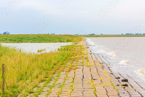 Dyke dike mudflat waves landscape North Sea coast Nordenham Germany. photo