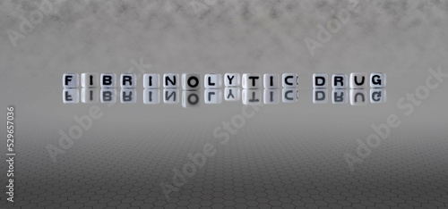 fibrinolytic drug word or concept represented by black and white letter cubes on a grey horizon background stretching to infinity photo