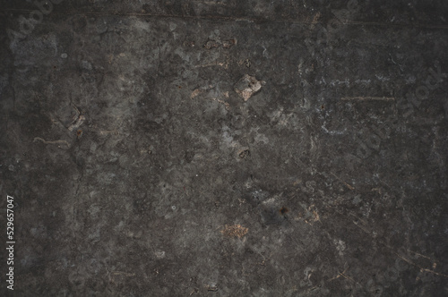 Darkened concrete surface with stains and scuffs, grungy vintage background close-up, grunge texture.