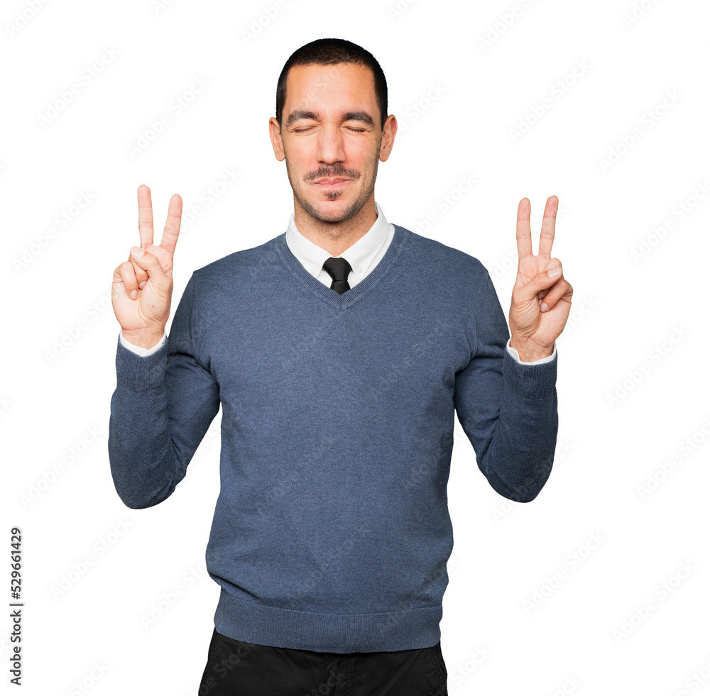 Happy young man making a victory gesture with his fingers Happy young man making a victory gesture with his fingers