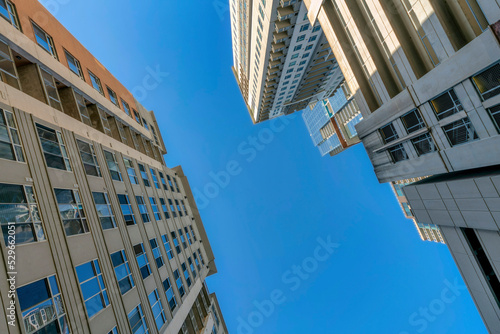 Blue sky on a sunny day with facade of apartments and covered parking garage