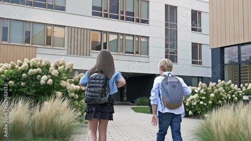 Meeting classmates in the school yard. A boy and a girl, elementary school students, greet each other when they meet.
