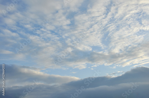 beautiful white clouds and blue sky in higher atmosphere and dark grey clouds in lower atmosphere with evening sunlight in rainy season