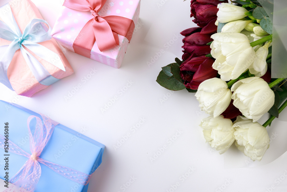 tulips and gift box on white background. Stylish soft image of spring flowers. Happy womens day. Happy Mothers day- Image tulips and gift box on white background. Stylish soft image of spring flowers. Happy womens day. Happy Mothers day- Image