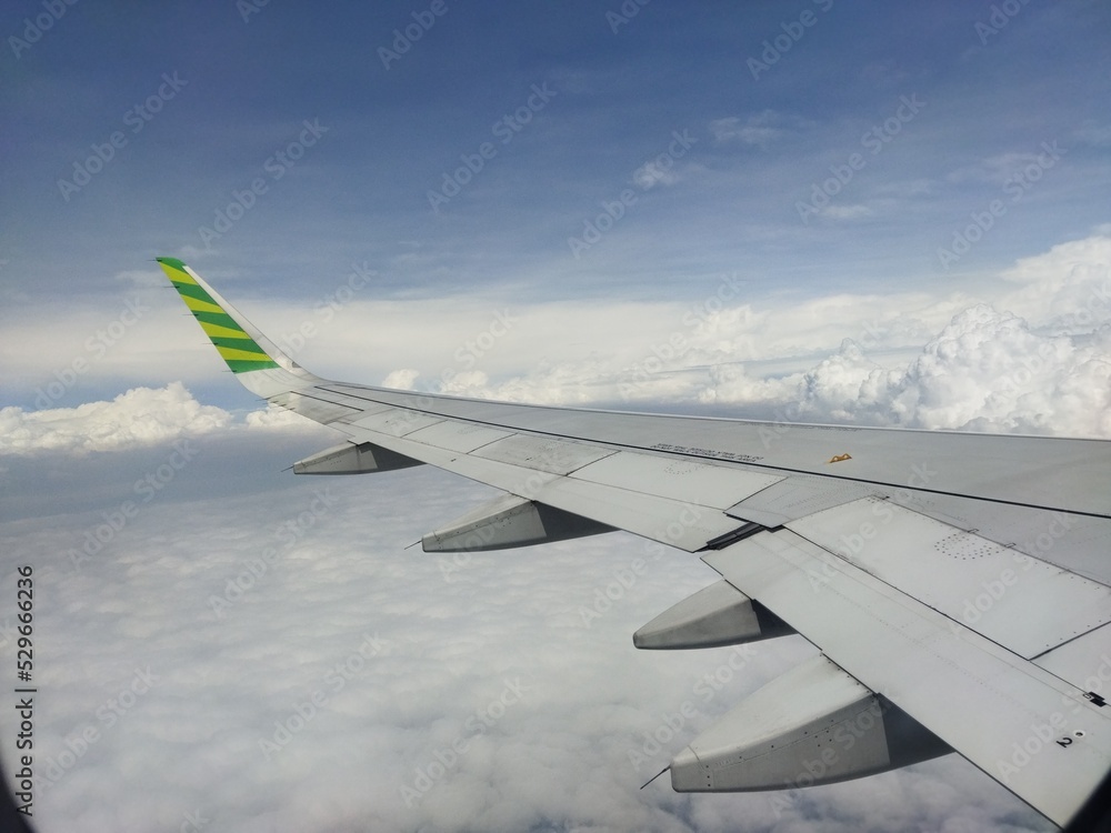 Fototapeta premium view of the clouds san airplane wing from above the clouds