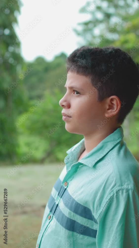 latin boy posing while looking at nature, medium shot latin boy posing while looking at nature, medium shot
