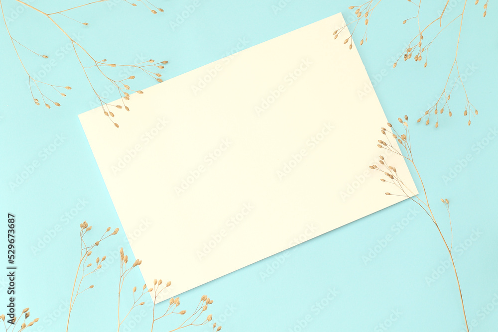 empty dry autumn flowers with empty paper page on pastel blue background empty dry autumn flowers with empty paper page on pastel blue background