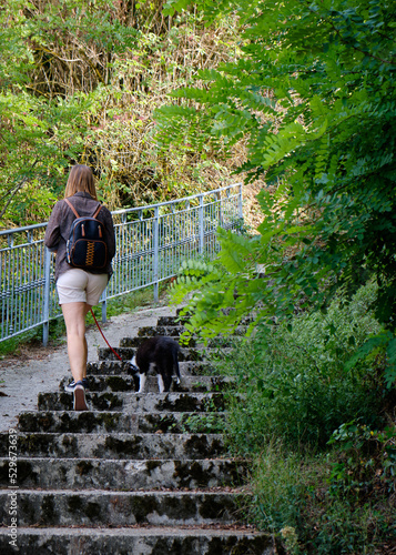 Foto scattata nel centro storico di Garbagna (AL) ad una ragazza a passeggio con un cucciolo di border collie.