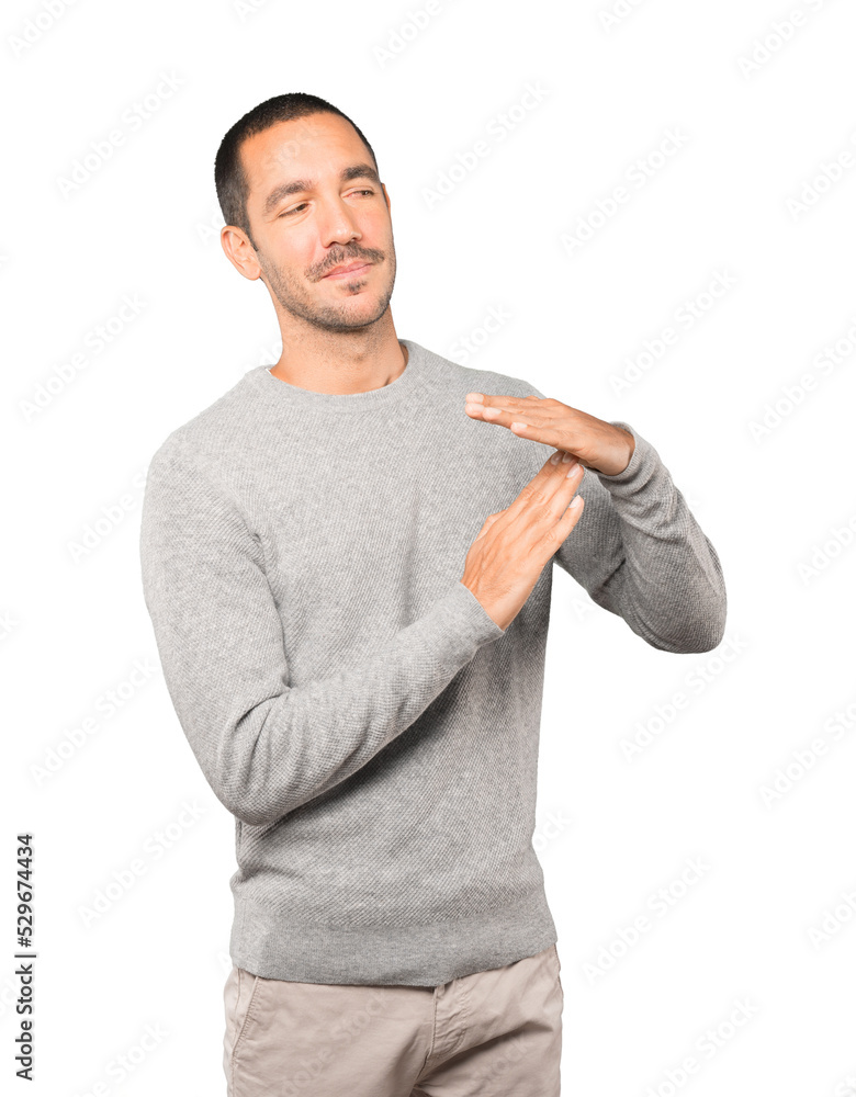 Friendly young man making a time out gesture with his hands Friendly young man making a time out gesture with his hands