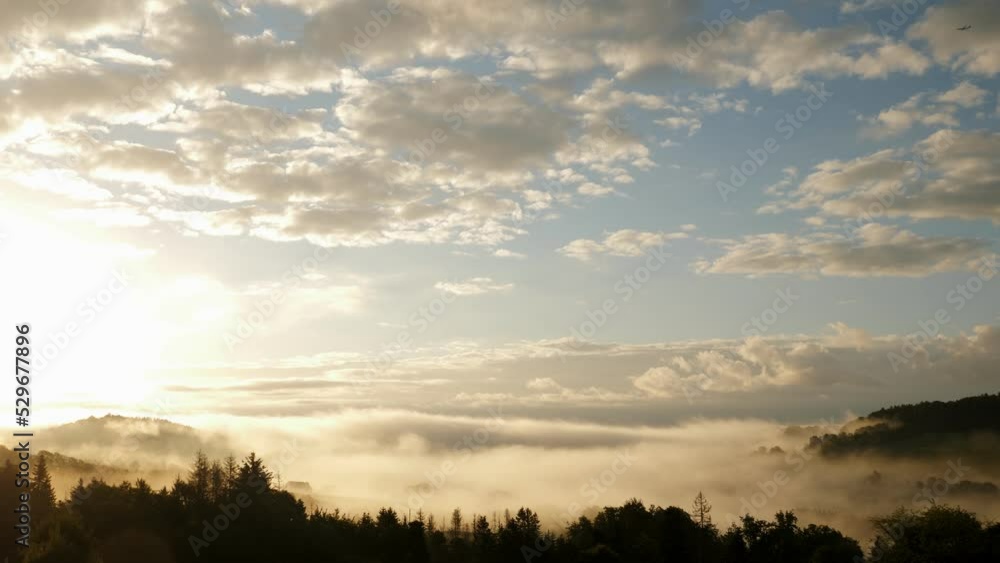 Clouds and mountains on golden sunrise. Morning misty fog over pine trees forest Clouds and mountains on golden sunrise. Morning misty fog over pine trees forest