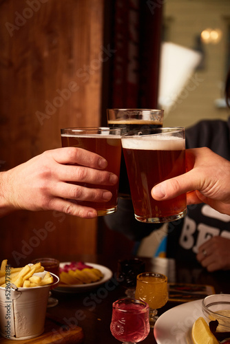 Man and woman drink beer in pub. Friends having alcoholic drinks in the bar